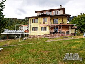 Планински ваканционен комплекс от къщи за гости, ресторант, басейни и паркови площи в резерват „Пеещ..